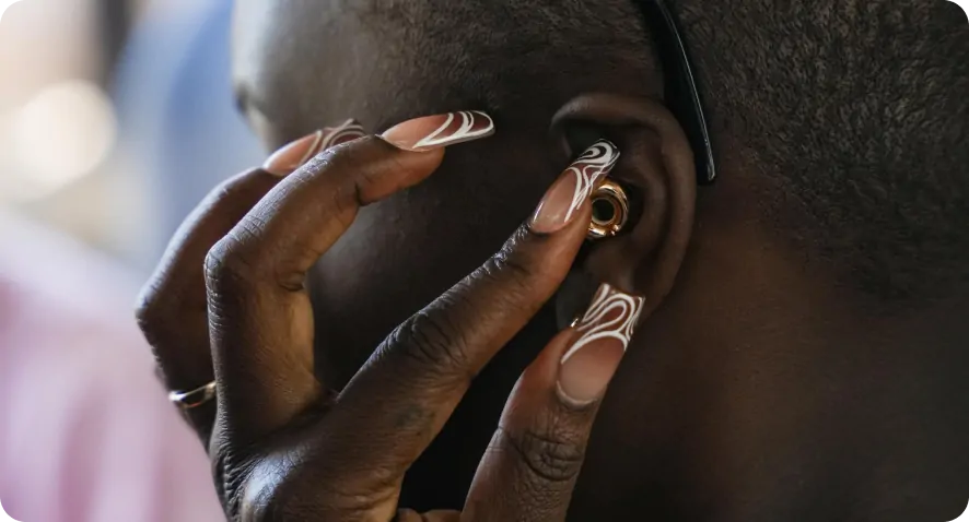 Person adjusting a gold earplug