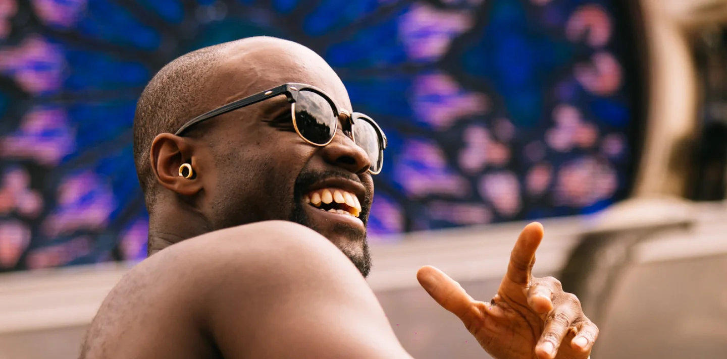 Smiling person at a music event wearing a gold earplug